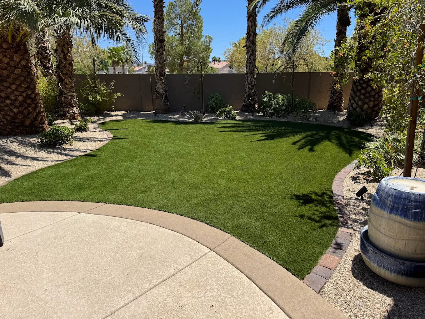 Las Vegas backyard with curved patio and clean artificial turf lawn