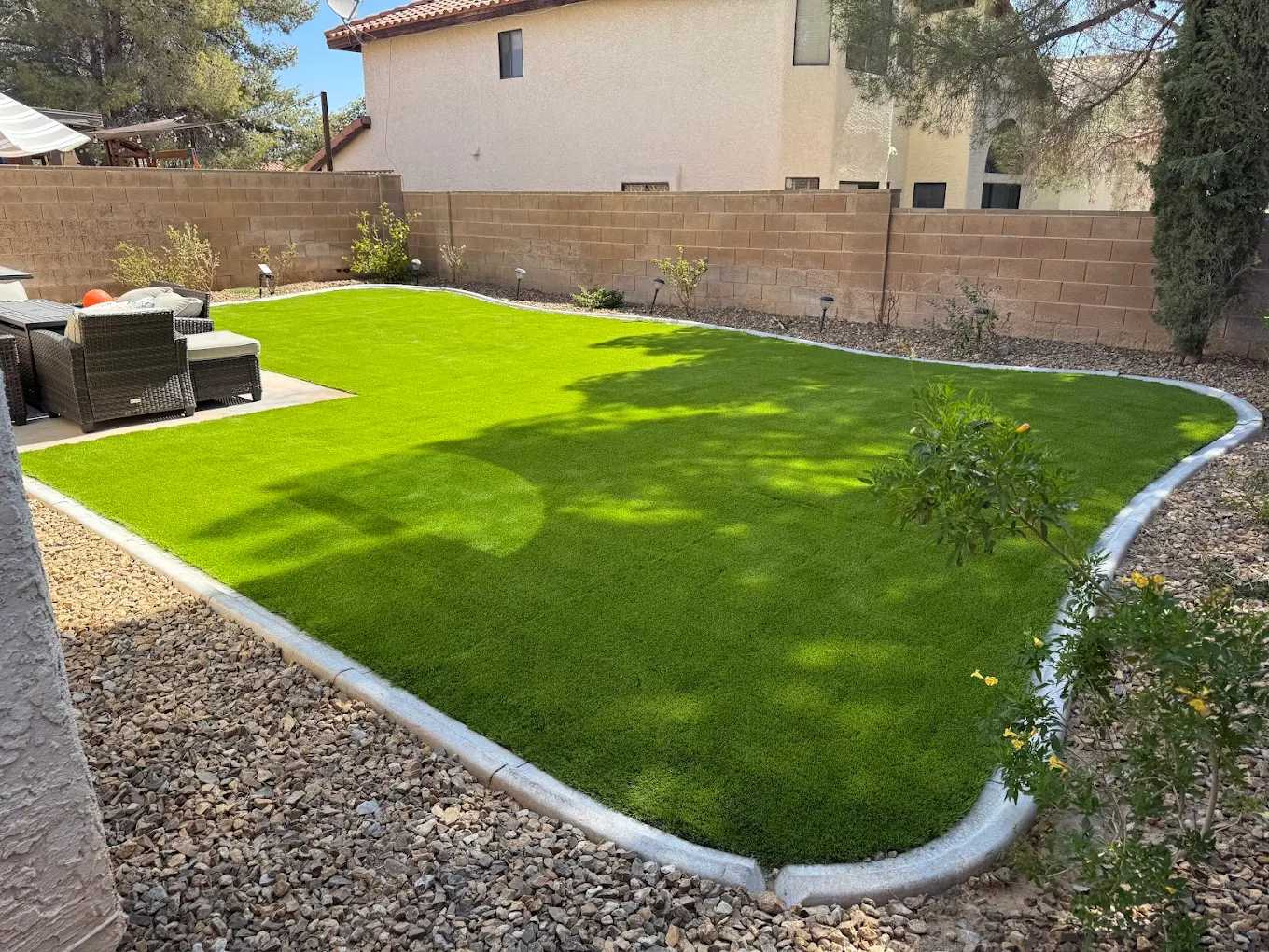 Large turf area with gravel border and patio furniture