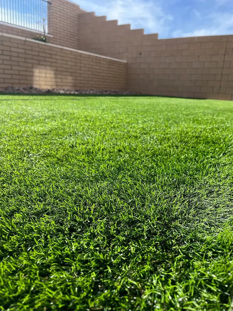 Close-up of multi-tone artificial turf color showing varied green and olive blade tones near outdoor stairs